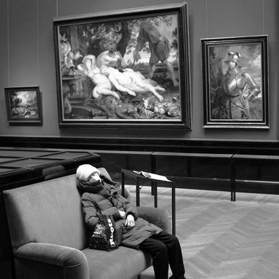Black and white street photography of the french street photographer David Décamps representing a woman sleeping in the middle of a museum in Vienna.