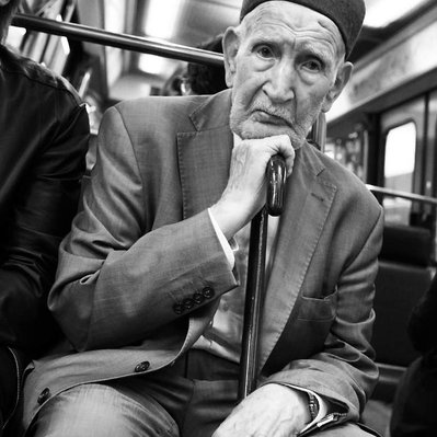 Black and white street photography of the french street photographer David Décamps representing a wise man with a sad look in the subway in Paris.