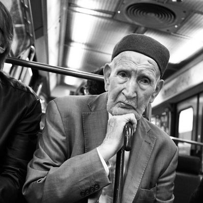 Black and white street photography of the french street photographer David Décamps representing a wise man with a sad look in the subway in Paris.
