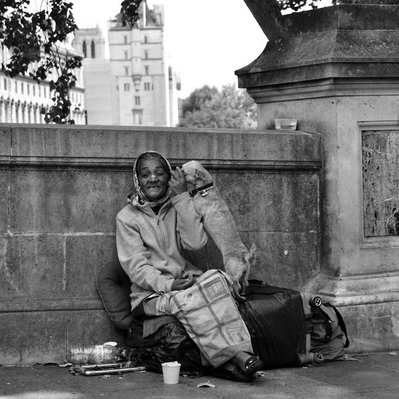 Black and white street photography of the french street photographer David Décamps representing a homeless woman with her dog in Paris.