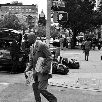 Black and white street photography of the french street photographer David Décamps representing an old man selling newspaper in New York City, USA.