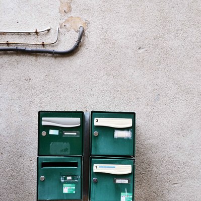Street photography in colors of the french street photographer David Décamps representing four green mailbox in France.