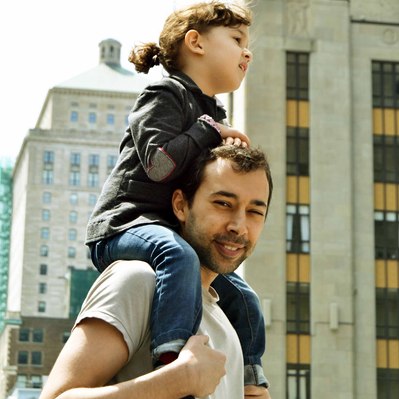 Street photography in colors of  the french street photographer David Décamps representing a dad with her daughter on his shoulders in Montréal.