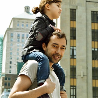 Street photography in colors of  the french street photographer David Décamps representing a dad with her daughter on his shoulders in Montréal.
