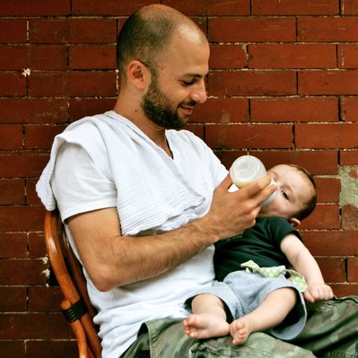 Street photography in colors of  the french street photographer David Décamps representing a dad feeding his baby in Brooklyn, New York City, USA.