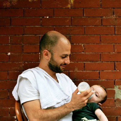 Street photography in colors of  the french street photographer David Décamps representing a dad feeding his baby in Brooklyn, New York City, USA.