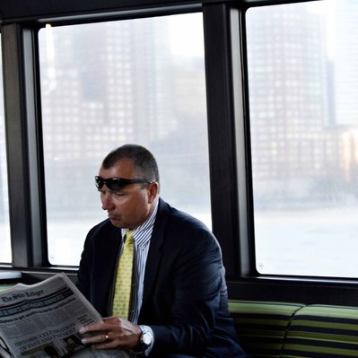 Street photography in colors of  the french street photographer David Décamps representing a man reading a newspaper in a boat in New York City, USA.