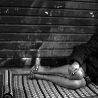 Black and white street photography of the french street photographer David Décamps representing a woman sleeping on the floor in Paris.