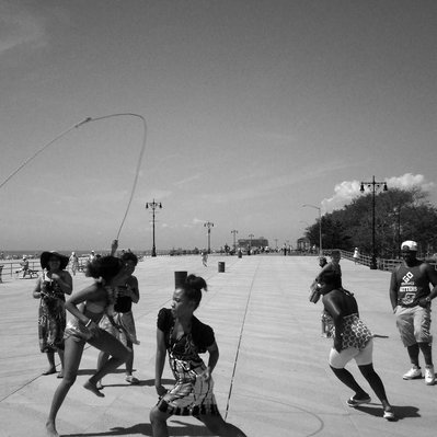 Black and white street photography of the french street photographer David Décamps representing some people dancing on the beach in Coney Island, New York City, USA.