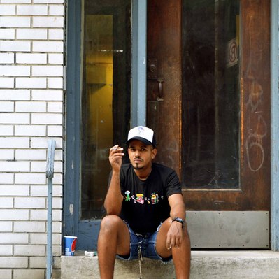 Street photography in colors of the french street photographer David Décamps representing a man smoking a cigarette on his stair in New York City, USA.