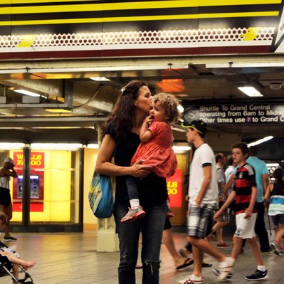 Street photography in colors of the french street photographer David Décamps representing a woman dancing with her baby in her hands in New York City, USA.