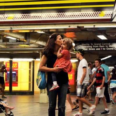 Street photography in colors of the french street photographer David Décamps representing a woman dancing with her baby in her hands in New York City, USA.