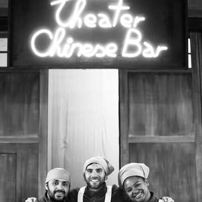 Black and white street photography of the french street photographer David Décamps representing three people in the kitchen of a theater in Paris.