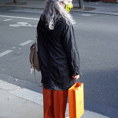 Street photography in colors of the french street photographer David Décamps representing a woman with a orange pants and bag in Paris.