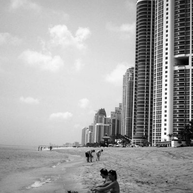 Black and white street photography of the french street photographer David Décamps representing a family and a baby on the beach in Miami, USA.