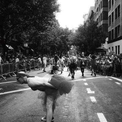Black and white street photography of the french street photographer David Décamps representing a man showing his dress during the LGBTQ+ walk in New York City, USA.