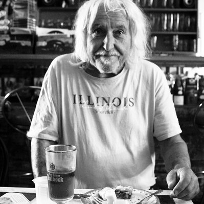 Black and white street photography of the french street photographer David Décamps representing a man having dinner alone in Massilly.
