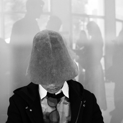 Black and white street photography of the french street photographer David Décamps representing a man with a hat similar to a mushroom.