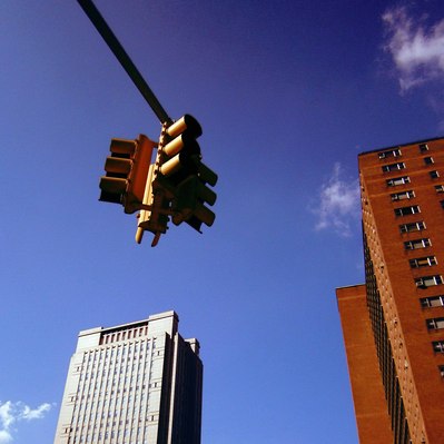Street photography in colors of the french street photographer David Décamps representing a traffic lights and two buildings in New York City, USA.