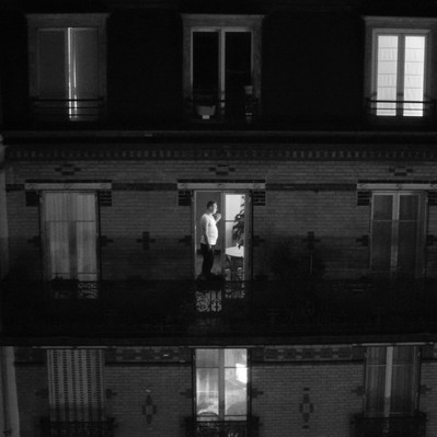Black and white street photography of the french street photographer David Décamps representing a man in his flat in Paris.