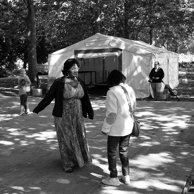 Black and white street photography of the french street photographer David Décamps representing a woman dancing in the sun light.