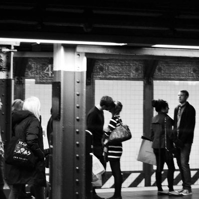 Black and white street photography of the french street photographer David Décamps representing a kiss between the teenagers in the subway in New York City, USA.