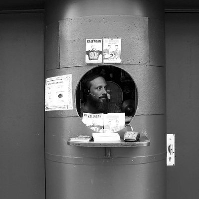 Black and white street photography of the french street photographer David Décamps representing a man in a counter as if he was in an aquarium in Paris.