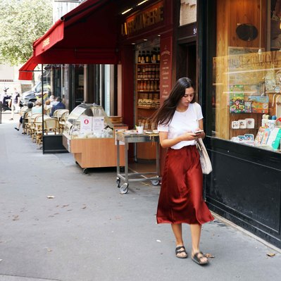 Street photography in colors of the french street photographer David Décamps representing a young woman with a red dress in Paris.
