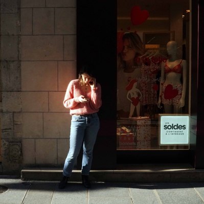 Street photography in colors of the french street photographer David Décamps representing a girl with a pink sweatshirt in Paris.