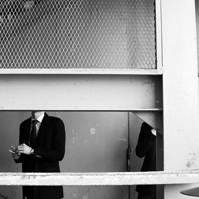 Black and white street photography of the french street photographer David Décamps representing two men without heads in Paris.