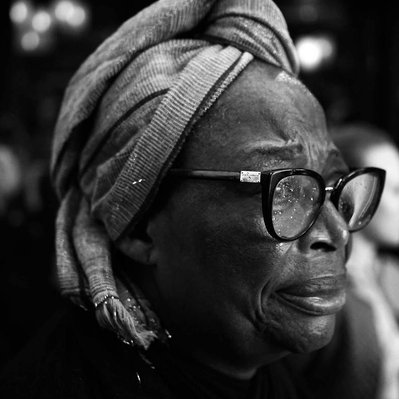 Black and white street photography of the french street photographer David Décamps representing a portrait of a woman who seems to cry in Paris.