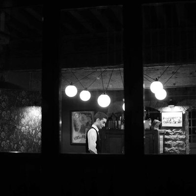 Black and white street photography of the french street photographer David Décamps representing a young man passing a job interview in a restaurant in Lyon.