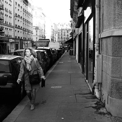 Black and white street photography of the french street photographer David Décamps representing a woman with the sun in her eyes in Paris.
