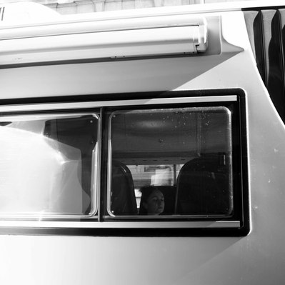 Black and white street photography of the french street photographer David Décamps representing a woman eyes closed in a car in Paris.