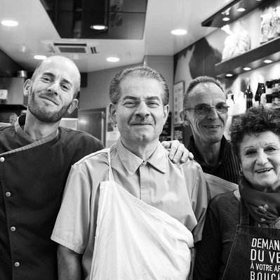 Black and white street photography of the french street photographer David Décamps representing the crew of butchers in front of their store in Paris.
