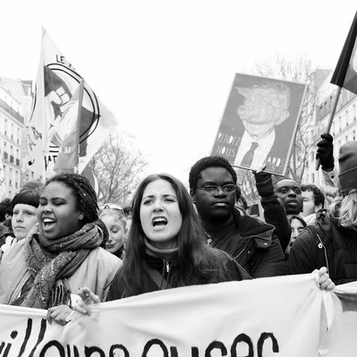 Black and white street photography of the french street photographer David Décamps representing a young woman screaming during a strike in Paris.