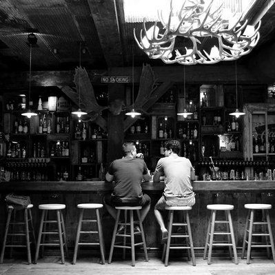 Black and white street photography of the french street photographer David Décamps representing two men sitting at a bar in Brooklyn, USA.
