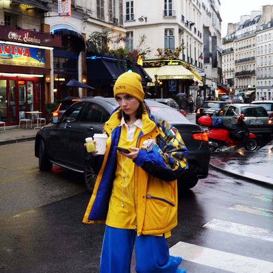 Street photography in colors of the french street photographer David Décamps representing a young woman wearing a yellow jacket under the rain in Paris.