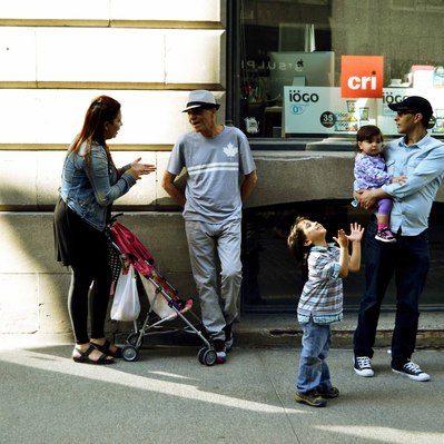 Street photography in colors of the french street photographer David Décamps representing a boy with his hands opened to the sky in Montreal.