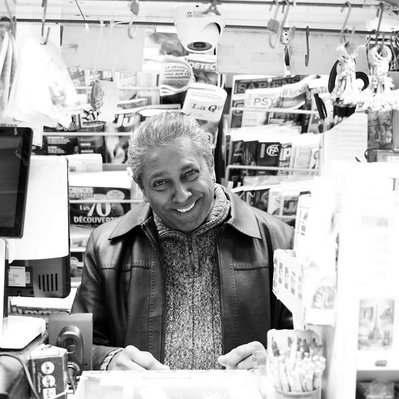 Black and white street photography of the french street photographer David Décamps representing a man with a big bright smile in Paris.