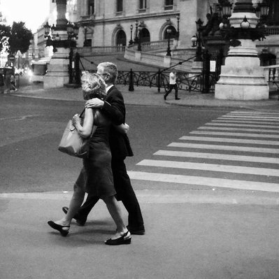 Black and white street photography of the french street photographer David Décamps representing a old couple walking side by side in front of the Opera in Paris.