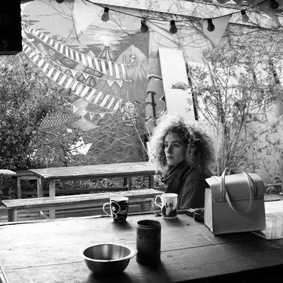 Black and white street photography of the french street photographer David Décamps representing a lost woman in a out bar in Paris.