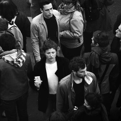 Black and white street photography of the french street photographer David Décamps representing some young people in a demonstration in Paris.