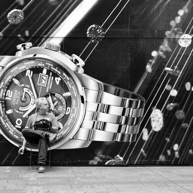 Black and white street photography of the french street photographer David Décamps representing a man sitting on a watch in New York City, USA.