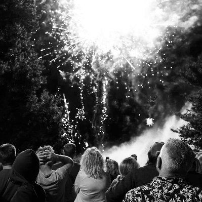 Black and white street photography of the french street photographer David Décamps representing a firework with a crowd in the  village of Gensac.