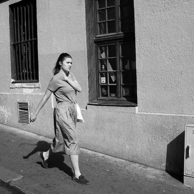 Black and white street photography of the french street photographer David Décamps representing a woman with her arm on her shoulder in Paris.