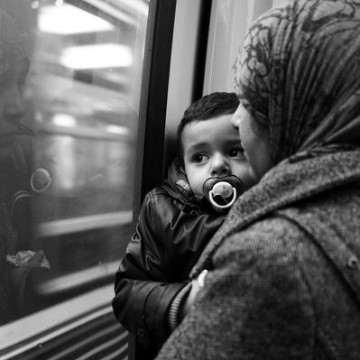 Black and white street photography of the french street photographer David Décamps representing a woman alone with her baby in her hand in the subway in Paris.