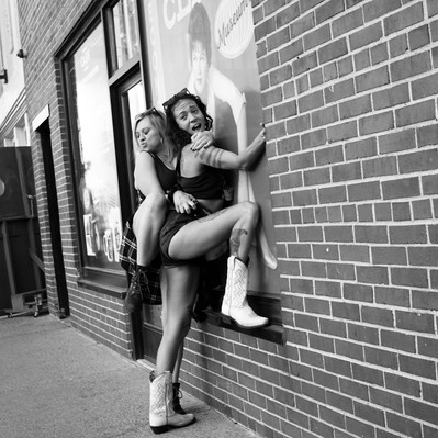 Black and white street photography of the french street photographer David Décamps representing two women doing crazy stuffs in Nashville, USA.