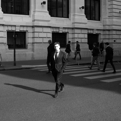 Black and white street photography of the french street photographer David Décamps representing a man crossing in the middle of the road in Paris.