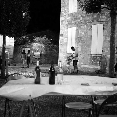 Black and white street photography of the french street photographer David Décamps representing a little girl dancing with his uncle during a party in the village of Gensac.